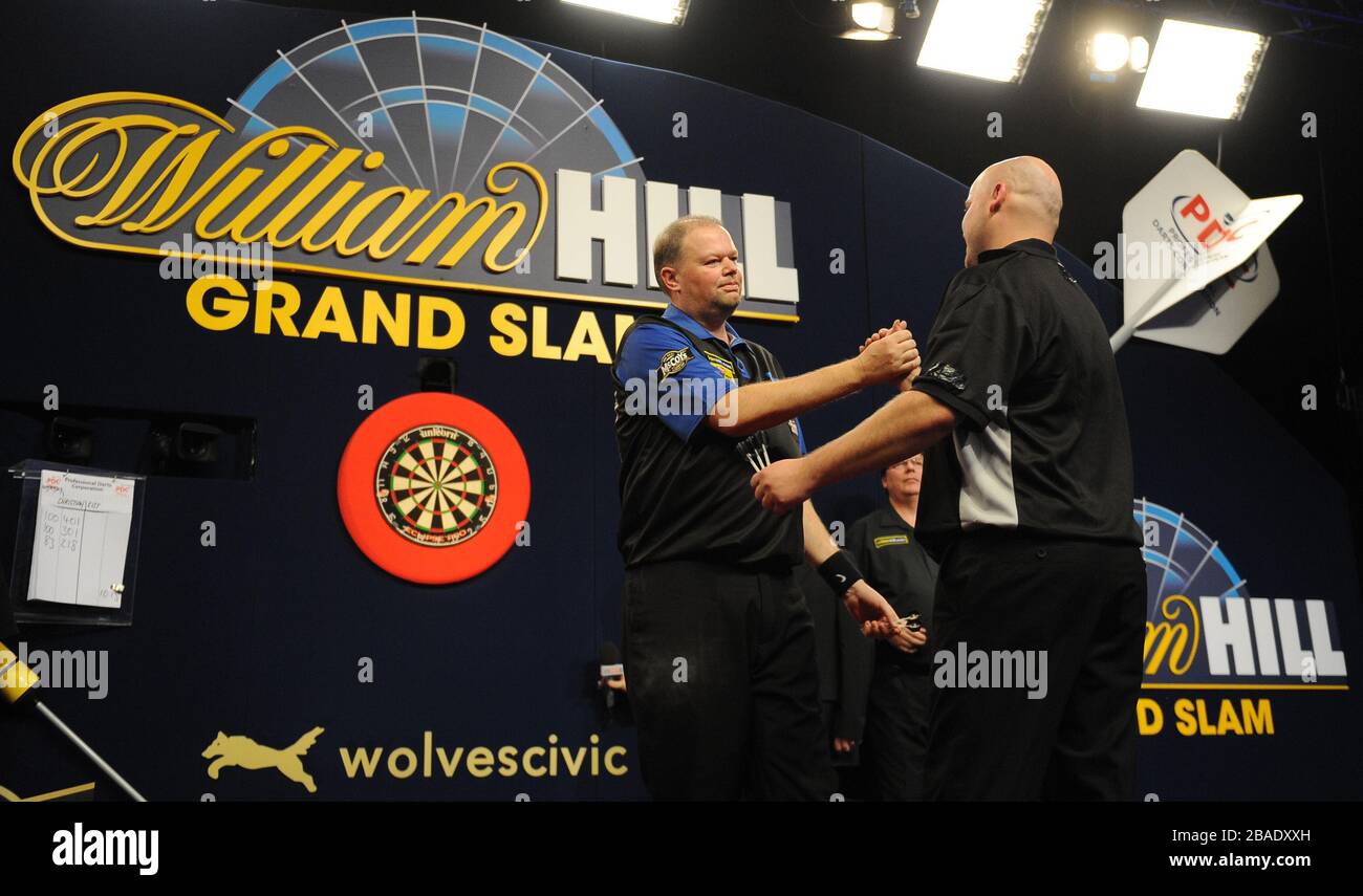 Raymond van Barneveld (al centro) si congratula con Christian Kist dopo la sua vittoria nelle quarti di finale. Foto Stock