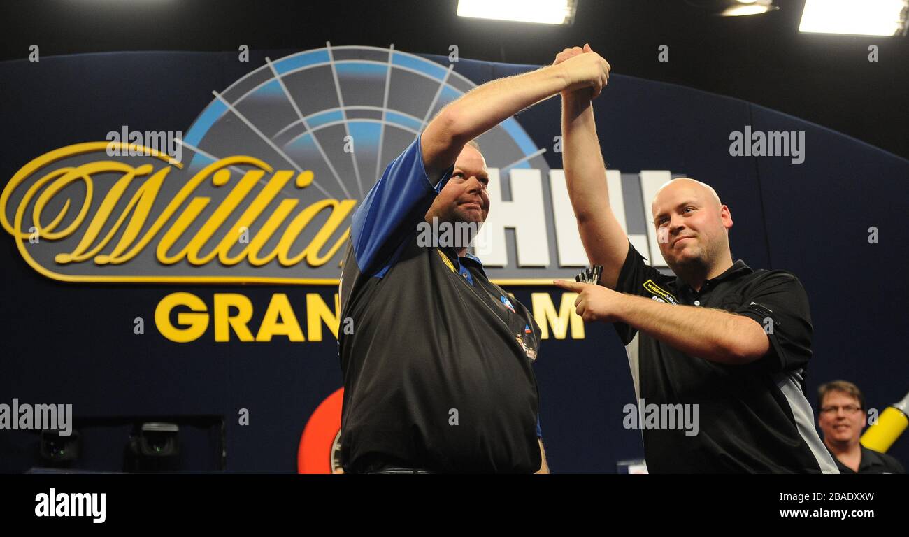 Raymond van Barneveld (al centro) si congratula con Christian Kist dopo la sua vittoria nelle quarti di finale. Foto Stock