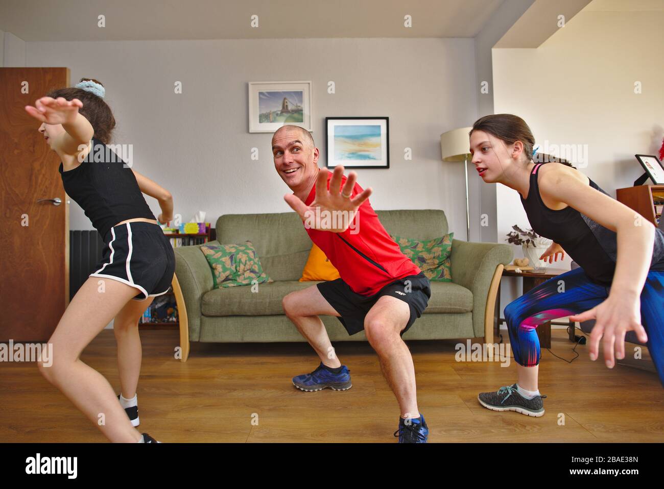 Famiglia a casa durante l'isolamento di Coronavirus Covid-19 che partecipa all'allenamento PE su YouTube di Joe Wicks Body Coach. 27 marzo 2020 Regno Unito Foto Stock