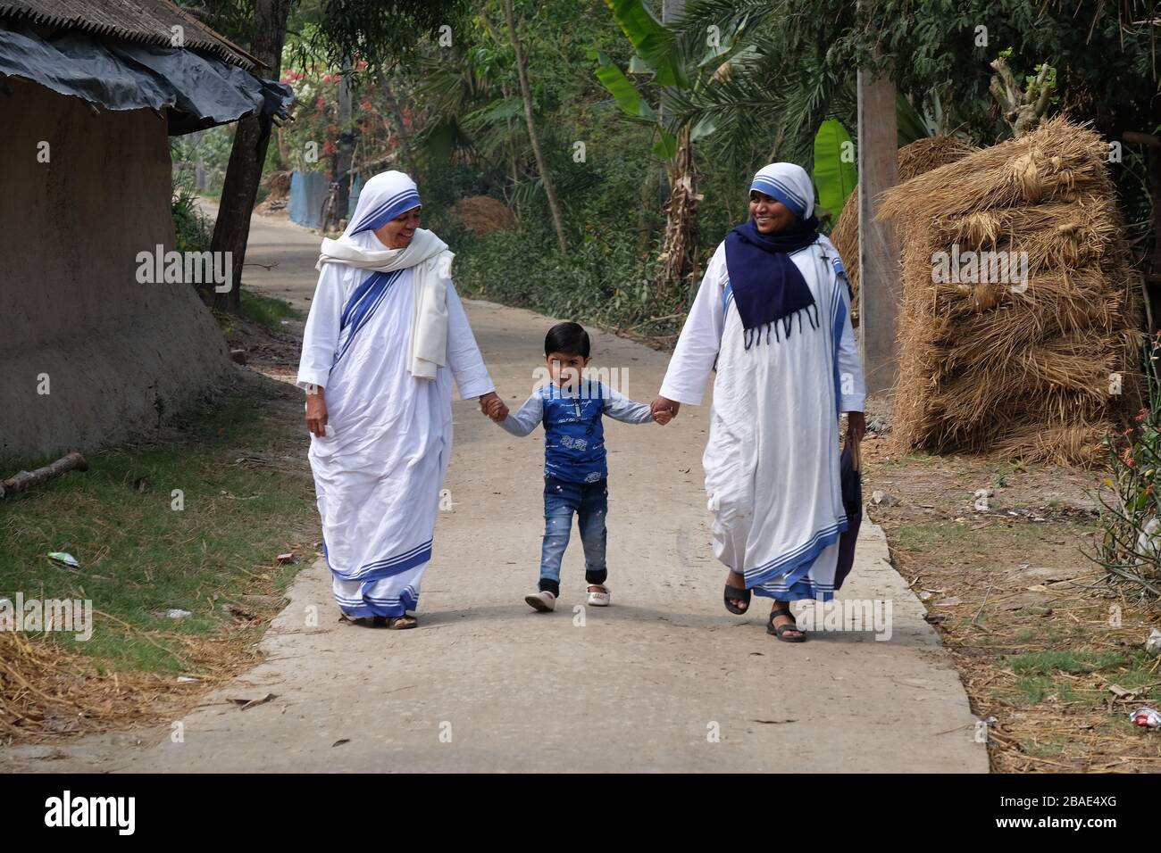 Missionari della Carità - le suore di Madre Teresa camminano con i bambini a Chunakhali, Bengala Occidentale, India Foto Stock
