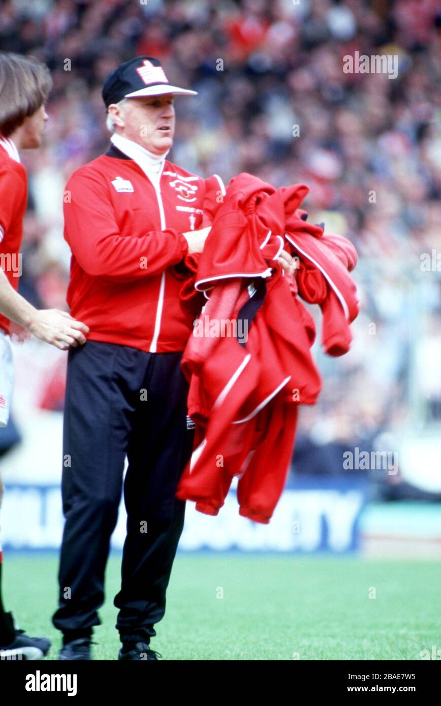 L'allenatore del Manchester United Tommy Cavanagh raccoglie i top della tuta dei giocatori prima del calcio d'inizio Foto Stock