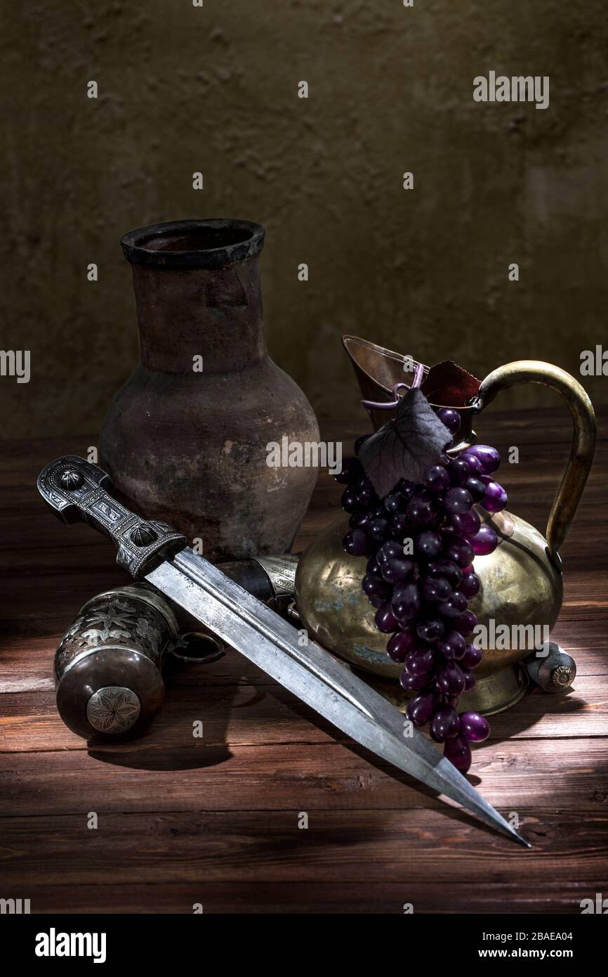 Bellissimo esempio di pugnale caucasico con matraccio in polvere d'argento e brocca in rame su sfondo di legno. 19th secolo (tempo delle guerre russo-caucasiche (1816-1 Foto Stock