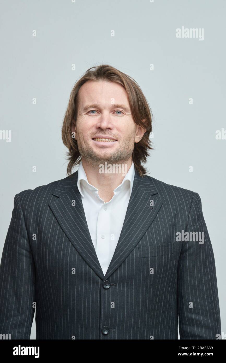 Il bell'uomo in tuta nera, brutale uomo con capelli lunghi, uomo d'affari,  molto elegante, ritratto, emozioni sul viso, vittoria, fiducia, piacere  Foto stock - Alamy