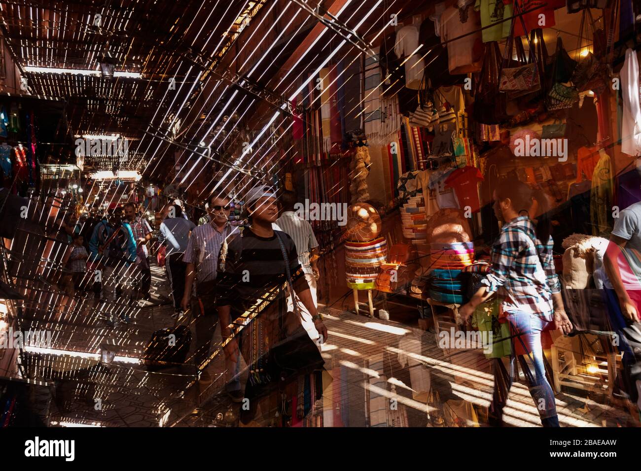 Strada trafficata all'interno della medina, città vecchia, con negozi di persone, 6 novembre 2017, Marrakech, Marocco. Immagine a doppia esposizione. Foto Stock