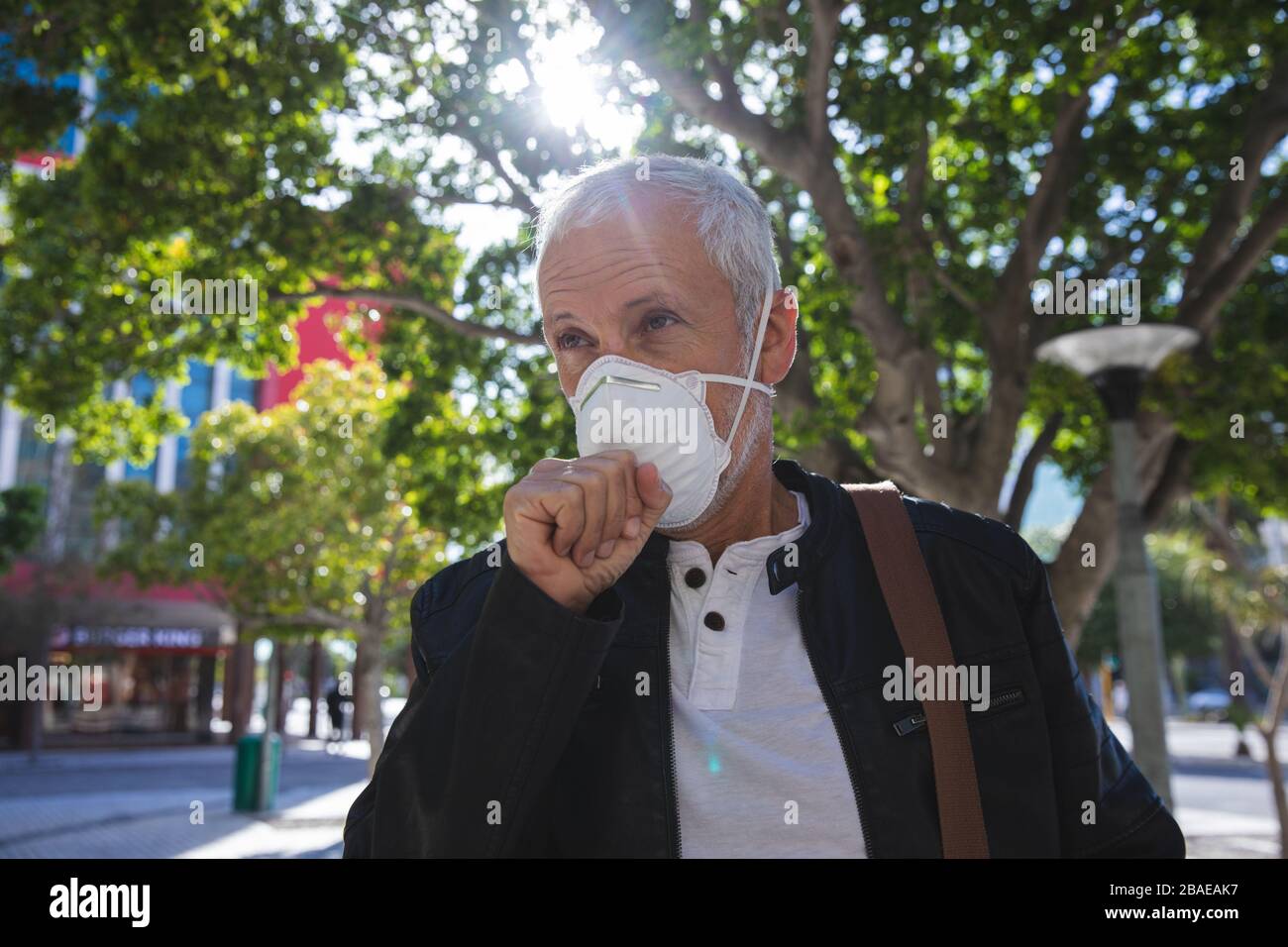 Uomo di mezza età che indossa la maschera di coronavirus Covid 19 in movimento Foto Stock