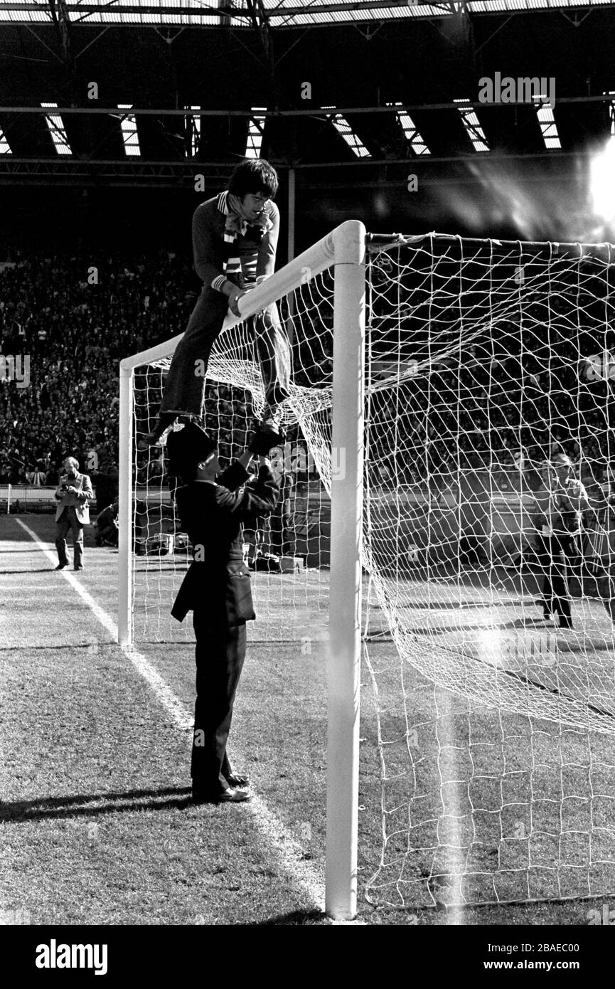 Un poliziotto di Wembley cerca di convincere un fan del Manchester United, celebrando la vittoria finale della fa Cup della sua squadra, a scendere dal crossbar Foto Stock