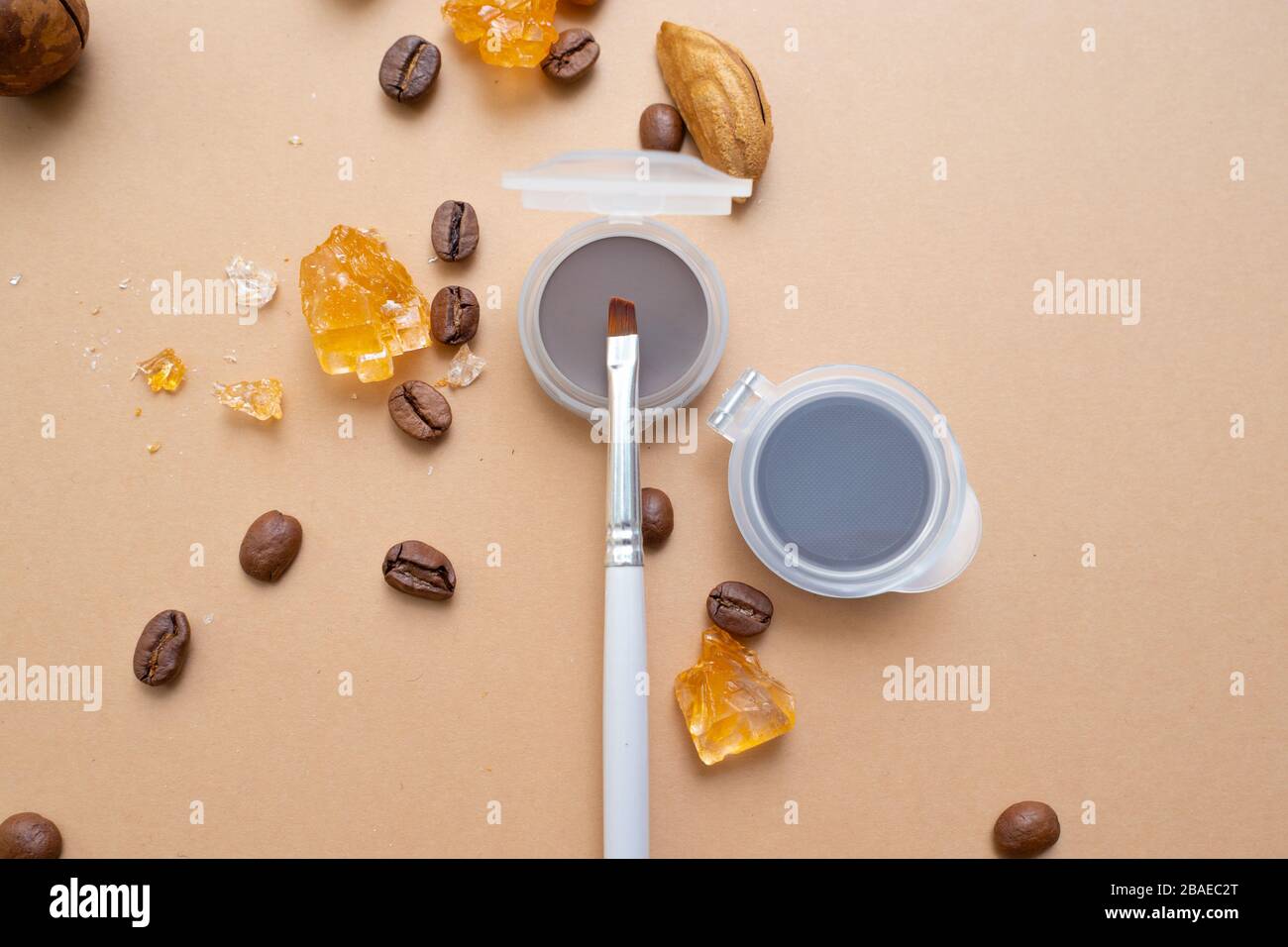 Cosmetici per il trucco naturale, prodotti per il trucco Eyebrow. Sfondo caldo con frutta secca e caffè. Foto Stock