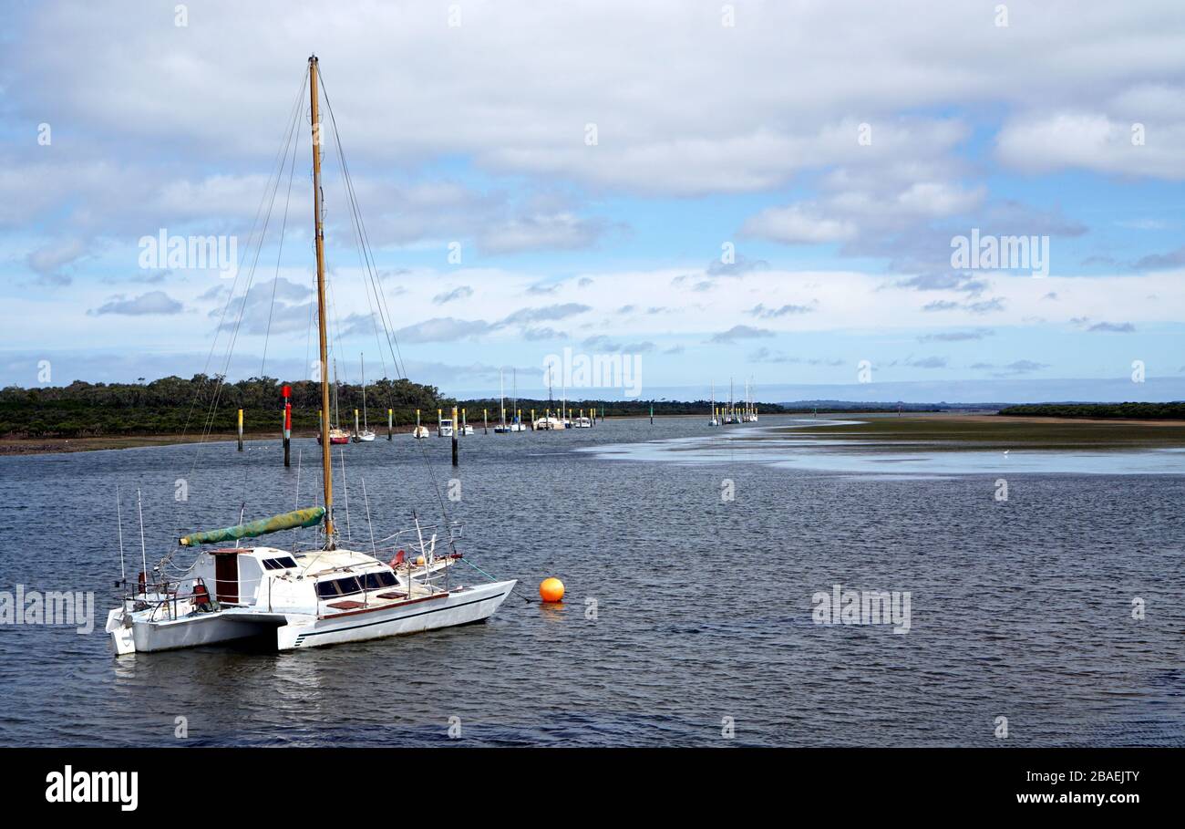Imbarcazione bianca semplice ormeggiata in acqua in giornate nuvolose Foto Stock