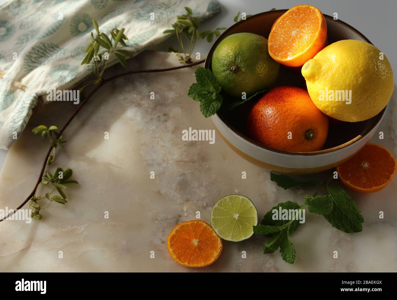 Ancora vita con frutta e menta arancione su piano in marmo bianco e tela. Foto Stock