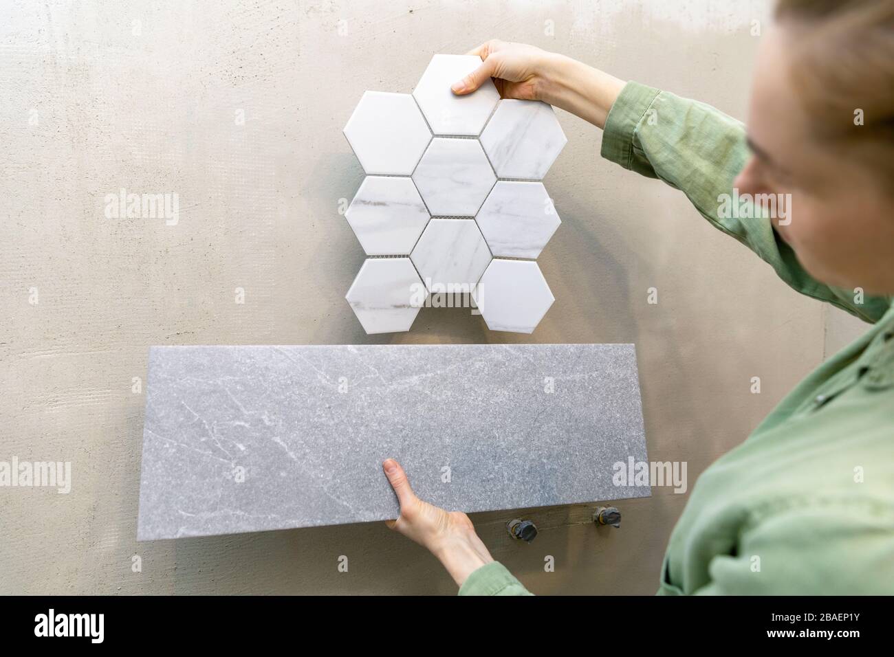 designer di interni cercando nuove piastrelle sulla parete per il design degli interni del bagno Foto Stock