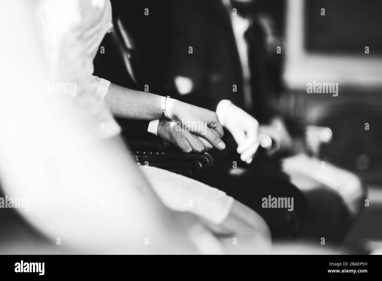 le coppie di nozze tengono le mani al cerenomy, sedendosi all'interno dell'ufficio del registro Foto Stock