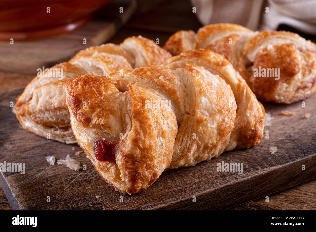 Deliziosi mini strudel in ciliegio intrecciato su un piano in legno rustico. Foto Stock