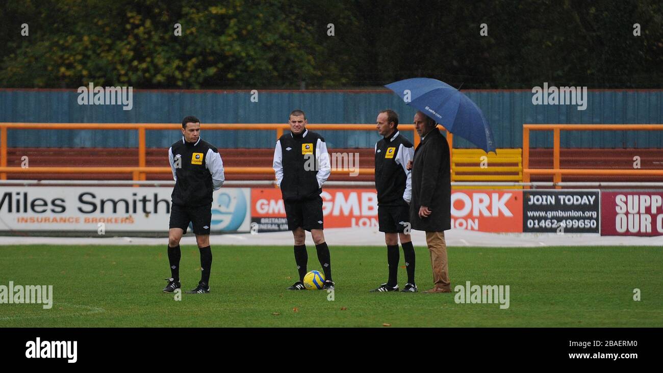 I funzionari della partita controllano il campo prima dell'abbandono del gioco btween Braintree Town's e Tranmere Rovers'. Foto Stock