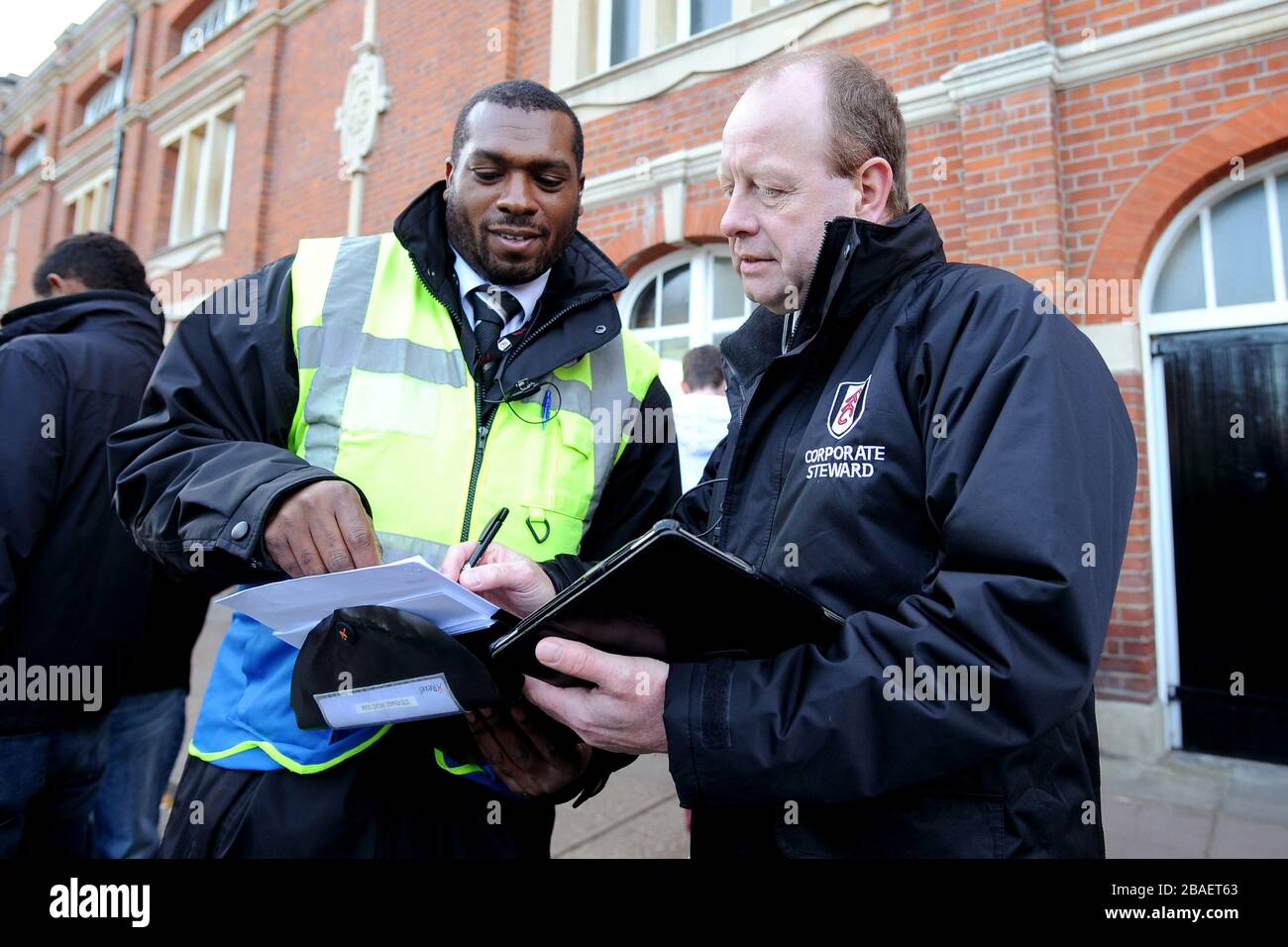 Gli steward di Fulham aiutano i tifosi intorno allo stadio il giorno della partita Foto Stock