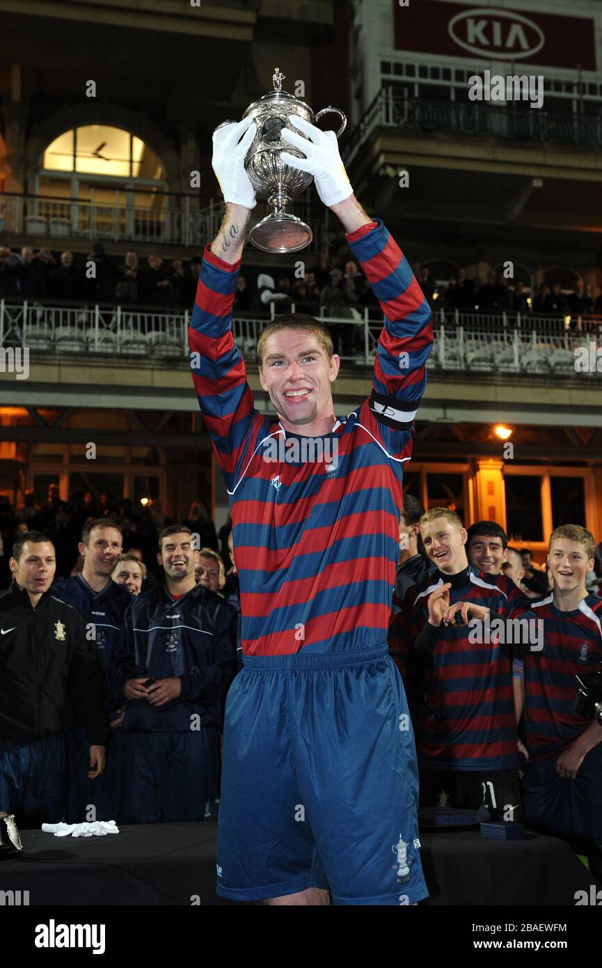 Il caporale della lancia James Hubbard, capitano della squadra di calcio dei Royal Engineers, tiene in alto la fa Cup originale dopo che la sua squadra ha battuto i Wanderers in una riproduzione della finale 1872 Foto Stock