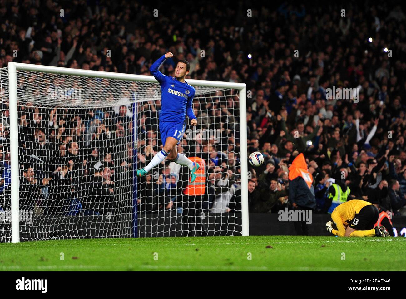 *ALTERNATE CROP* l'Eden Hazard di Chelsea festeggia dopo aver segnato il terzo goal della sua squadra mentre il portiere del Manchester United Anders Lindegaard si trova deiettato a terra Foto Stock