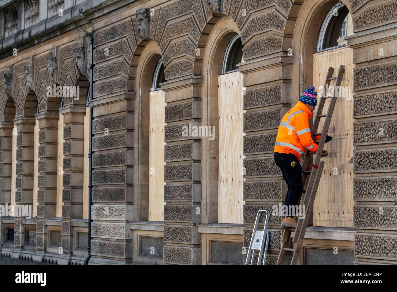 I lavoratori salgono le finestre di un ristorante a Bath, Somerset, dopo che il governo britannico ha annunciato restrizioni severe per cercare di contenere Coronavirus. Foto Stock