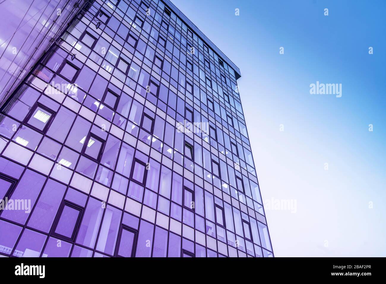 edificio in vetro contro il cielo. Design urbano moderno, sfumatura viola-blu, linee. Foto Stock