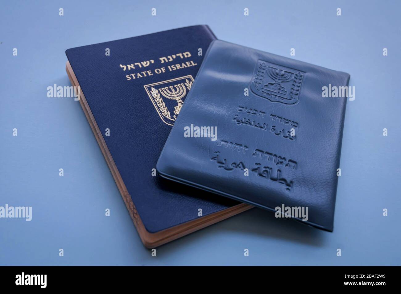 Documenti ufficiali israeliani: Passaporto di Israele e documento di identità nazionale su sfondo blu con una piccola bandiera di Israele. Concetto di cittadinanza israeliana Foto Stock