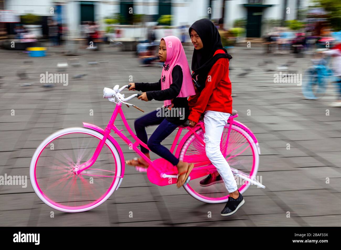 I bambini indonesiani in bicicletta a Taman Fatahillah Square, Jakarta, Indonesia. Foto Stock