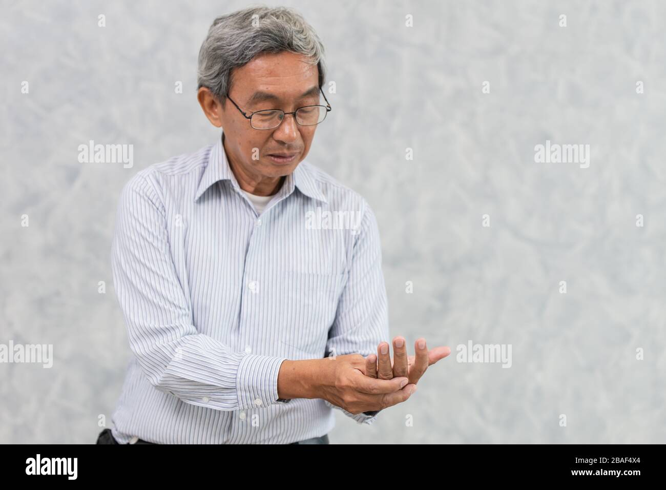 Dolore alle mani degli anziani con Trigger Finger o artrite reumatoide. Foto Stock