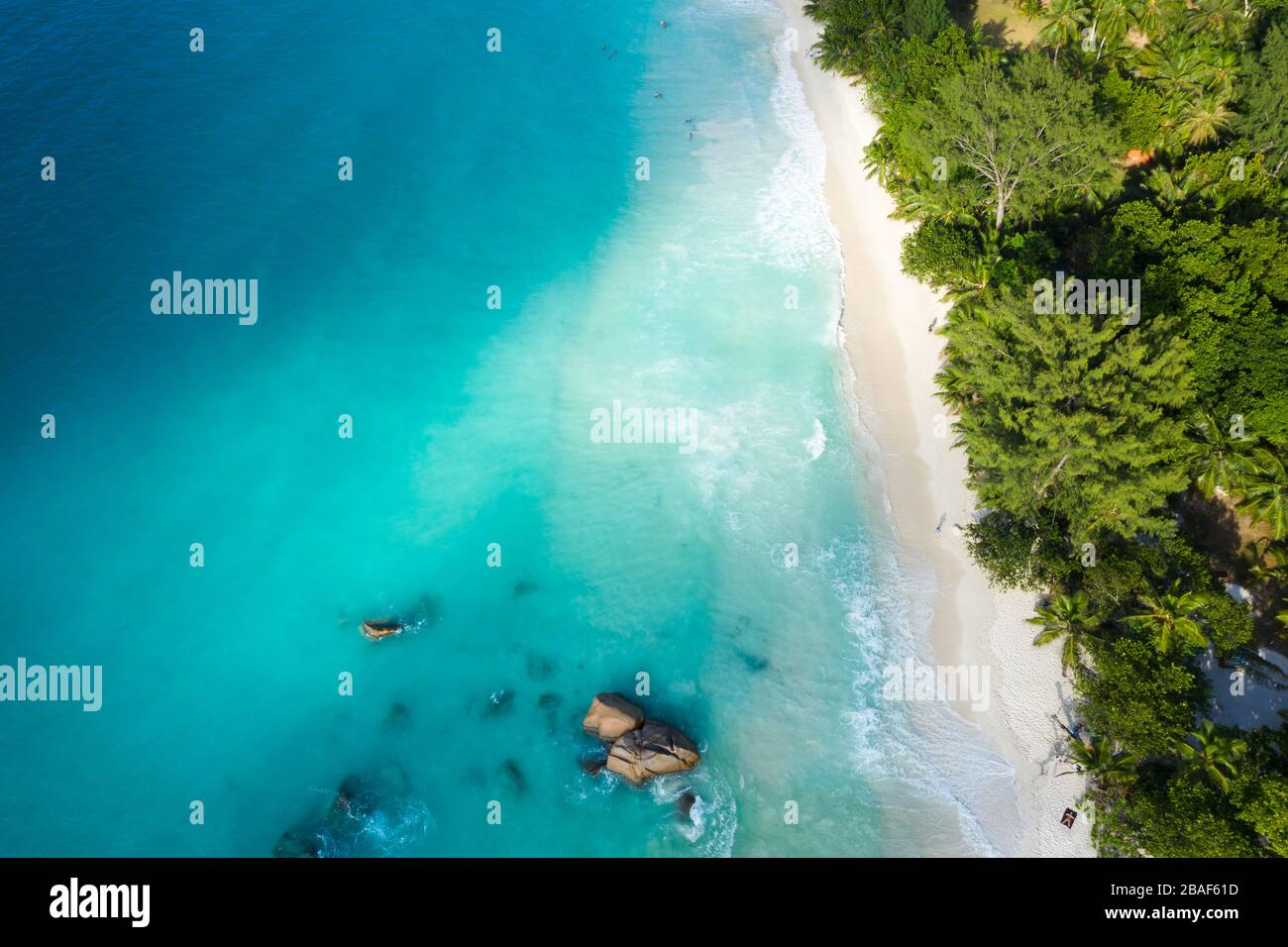 Vista aerea dall'alto verso il basso della spiaggia di Anse Lazio con sabbia bianca, acque turchesi e nuotatori, Praslin, Seychelles Foto Stock