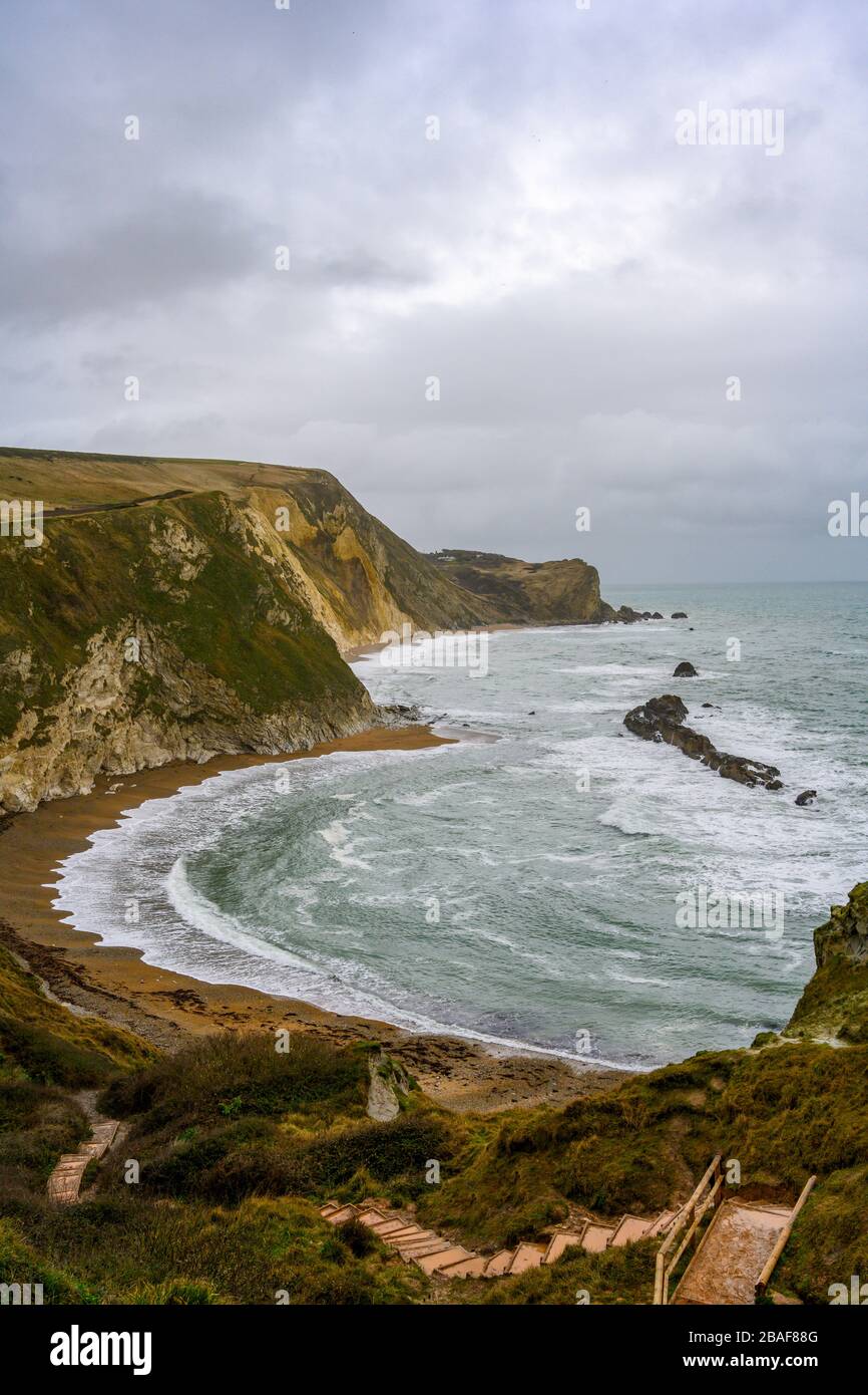 Vista portait di Man o War Bay a Dorset con splendidi motivi d'onda sulla spiaggia Foto Stock