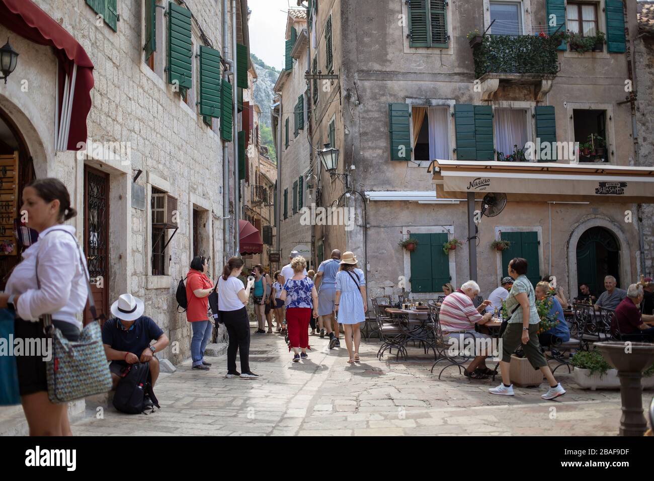 Montenegro, 17 settembre 2019: Una delle piazze con caffè all'aperto e turisti nella città vecchia di Cattaro Foto Stock