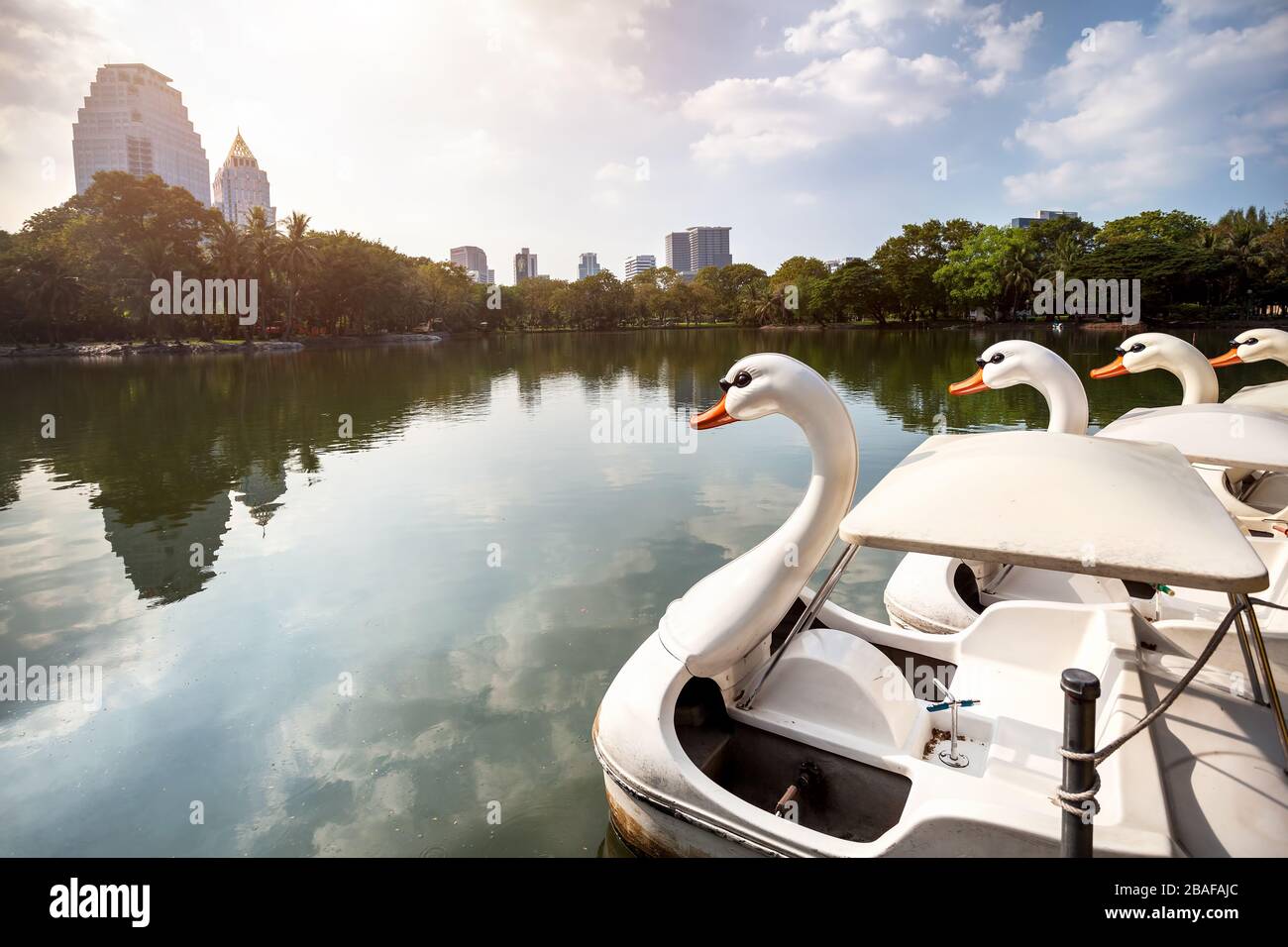 Il lago e la barca a forma di cigno bianco nel Centro Parco Lumpini di Bangkok, Thailandia Foto Stock