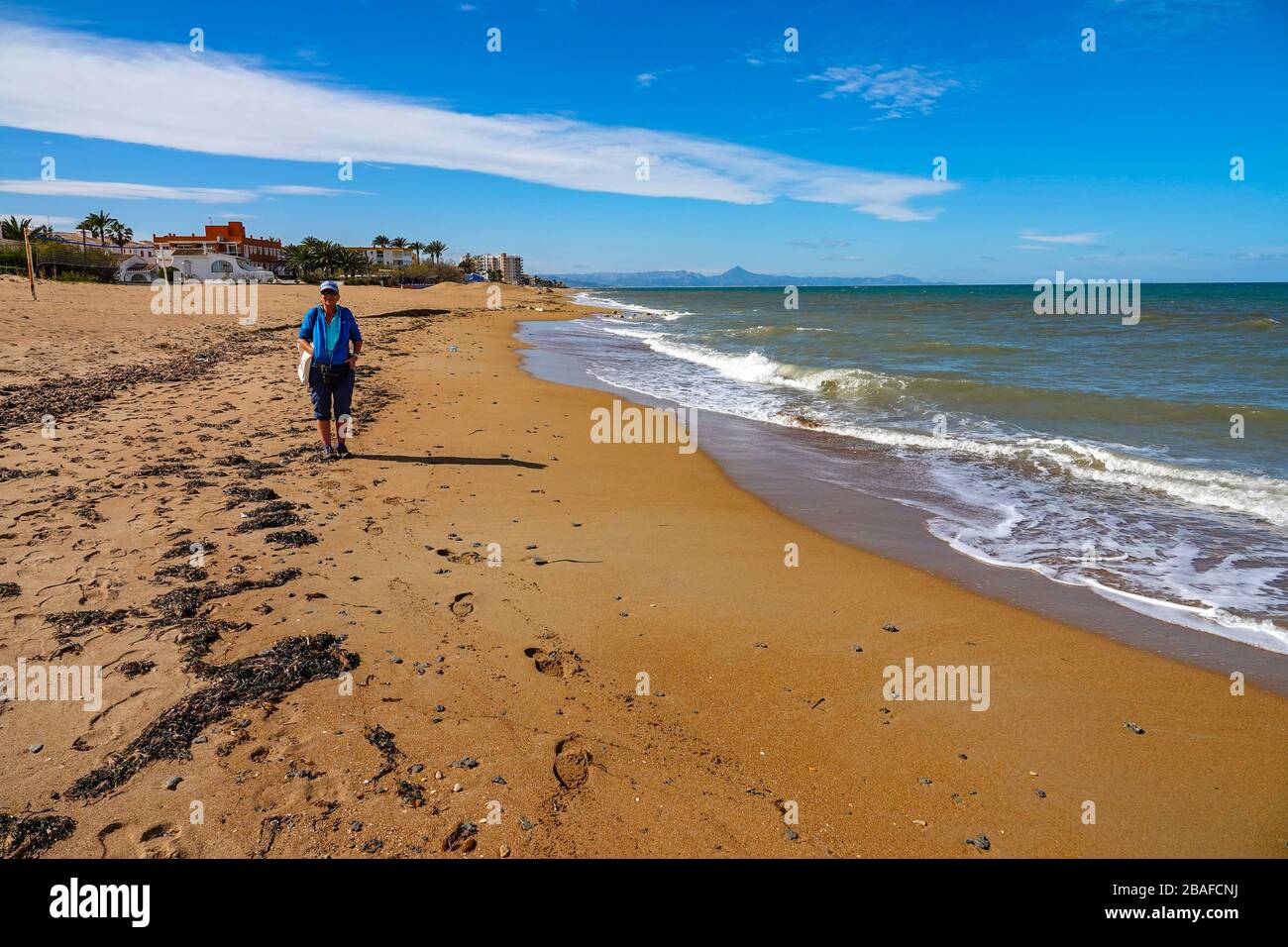 Solitaria femmina con borsetta su ampia spiaggia di sabbia deserta a Denia, Costa Blanca, Spagna Foto Stock