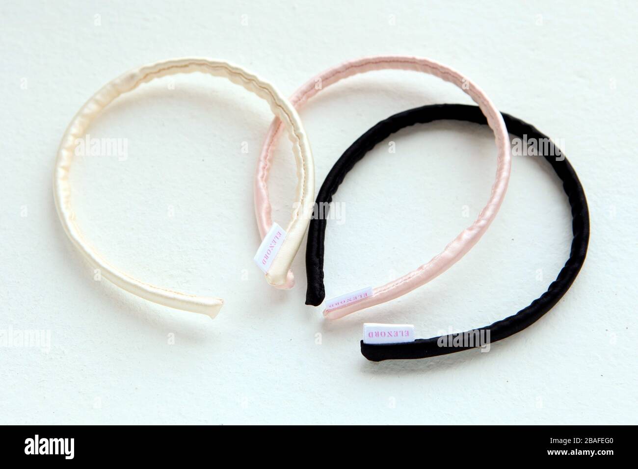 Nastri di seta giallo e rosa e Scrunchy isolati su bianco. Accessori e accessori per parrucchieri piatti colorare le crunchies dei capelli, elastici per capelli, Foto Stock