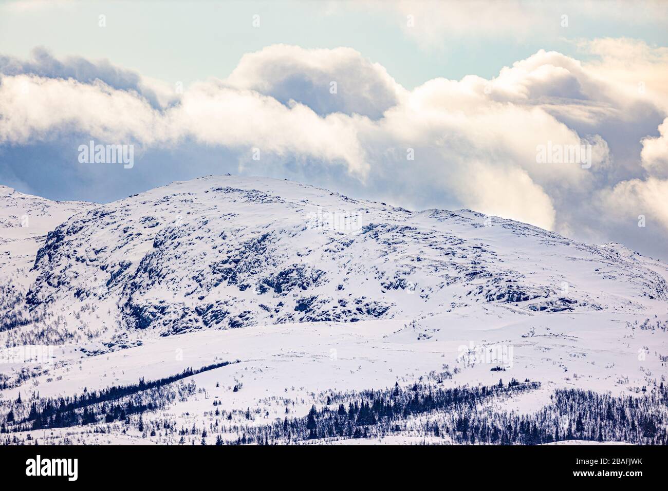 Neve coperta montagna e cielo con nuvole in Norvegia Foto Stock