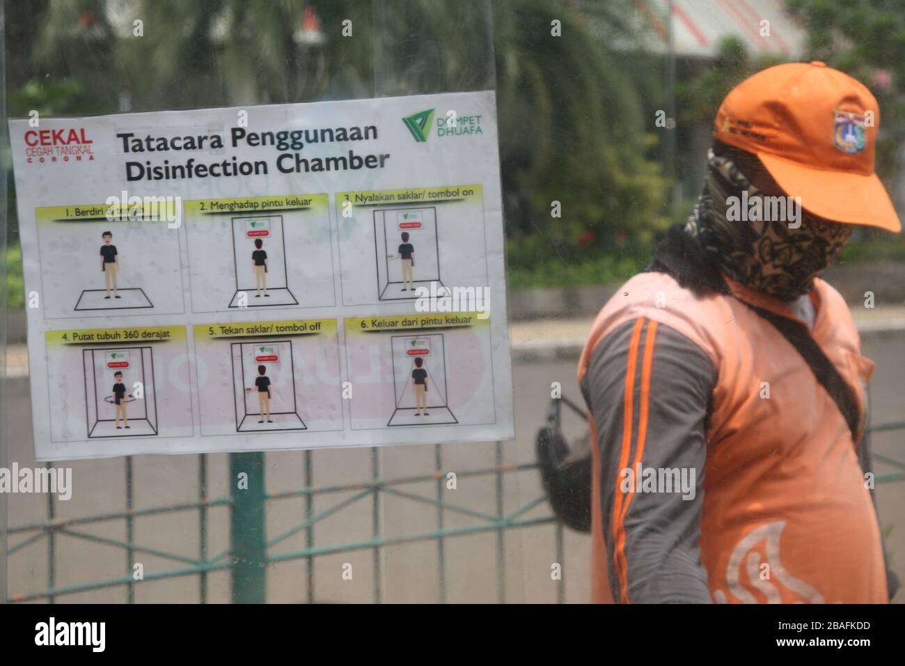 I residenti che saranno attivi in luoghi pubblici, utilizzano la camera di disinfezione di Blok M, South Jakarta, Indonesia il 25 marzo 2020. In questa camera di sterilizzazione tutto il corpo della persona verrà spruzzato con liquido disinfettante. Questo liquido disinfettante ha la funzione di uccidere il virus della corona che si attacca ai vestiti o al corpo della persona, per anticipare la diffusione del virus della corona (COVID-19) negli spazi pubblici. (Foto di Kuncoro Widyo Rumpoko/Pacific Press/Sipa USA) Foto Stock