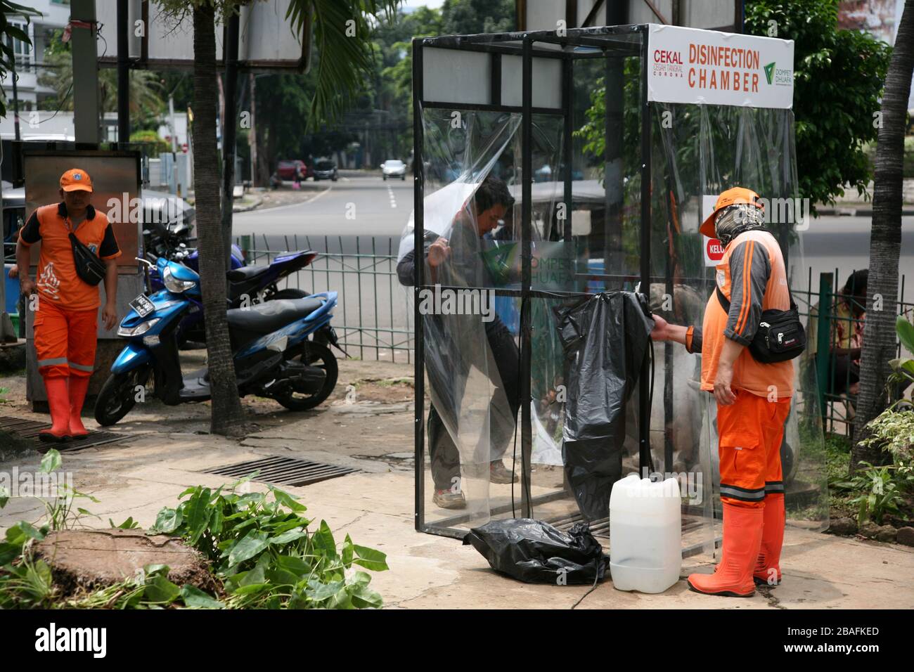 I residenti che saranno attivi in luoghi pubblici, utilizzano la camera di disinfezione di Blok M, South Jakarta, Indonesia il 25 marzo 2020. In questa camera di sterilizzazione tutto il corpo della persona verrà spruzzato con liquido disinfettante. Questo liquido disinfettante ha la funzione di uccidere il virus della corona che si attacca ai vestiti o al corpo della persona, per anticipare la diffusione del virus della corona (COVID-19) negli spazi pubblici. (Foto di Kuncoro Widyo Rumpoko/Pacific Press/Sipa USA) Foto Stock