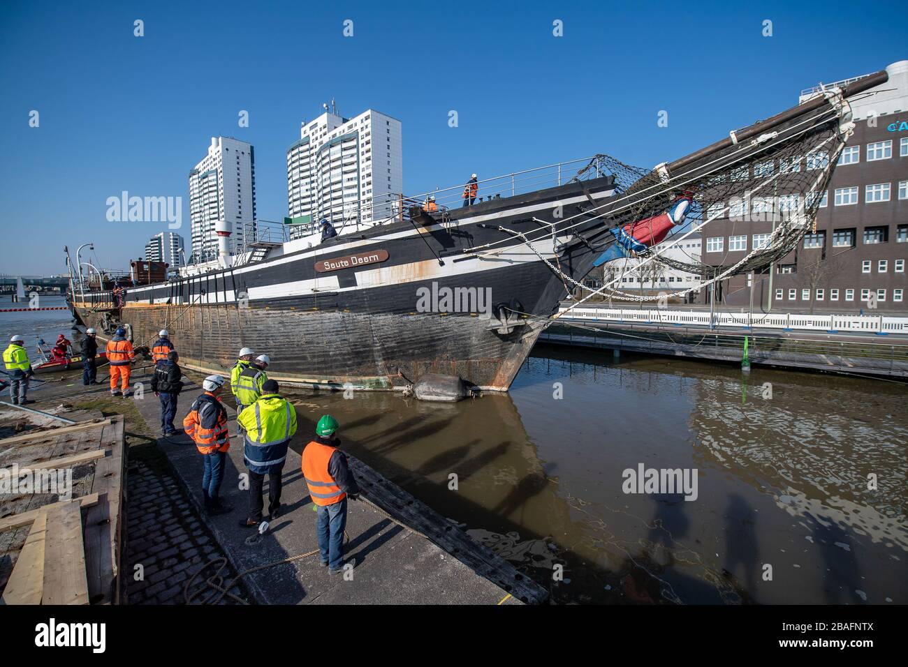 Bremerhaven, Germania. 27 marzo 2020. La nave a vela 'Salute Deern' viene tirata attraverso il porto. Il marinaio di 101 anni viene tirato dal suo ormeggio al Museo Marittimo tedesco a pochi metri in un bacino portuale vicino per essere demolito lì. Il punto di riferimento di Bremerhaven è una 'perdita totale costruttiva' e finalmente galleggiato solo con l'aiuto di pompe ad alte prestazioni. Credit: Sina Schuldt/dpa/Alamy Live News Foto Stock