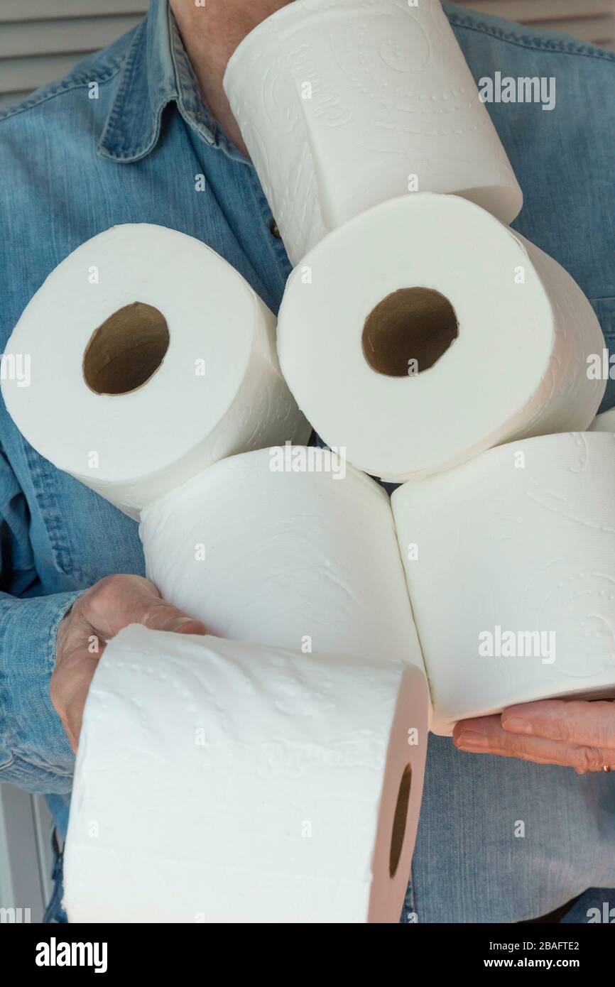 Uomo che tiene i rotoli supplementari di carta igienica durante la pandemia di Coronavirus, Stati Uniti Foto Stock