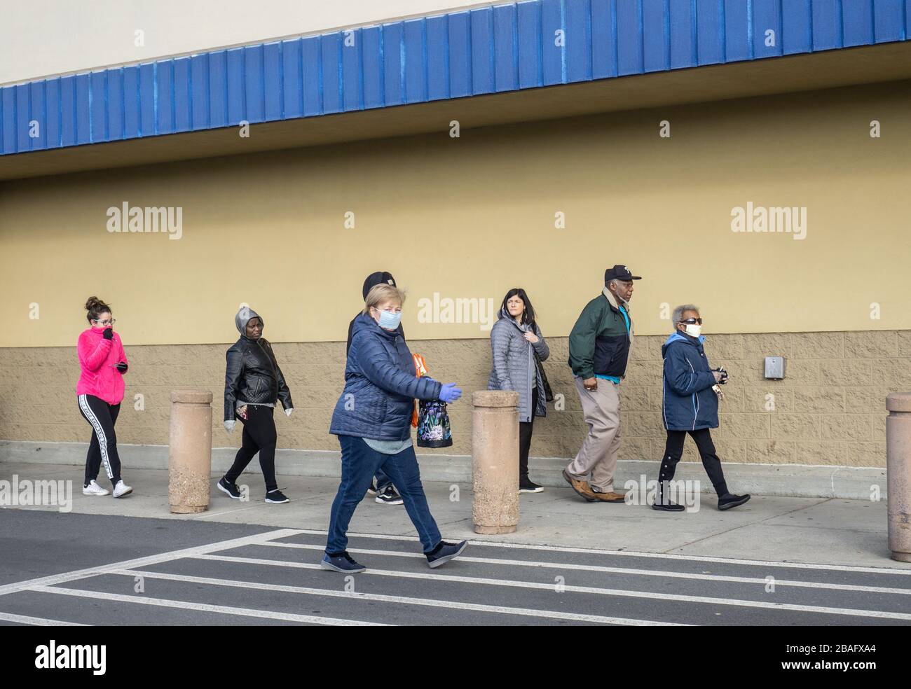 Reading, Berks County, Pennsylvania, Stati Uniti - 21 marzo 2020: Gruppo di persone in linea a piedi in box strore per forniture con alcune persone che indossano maschere Foto Stock