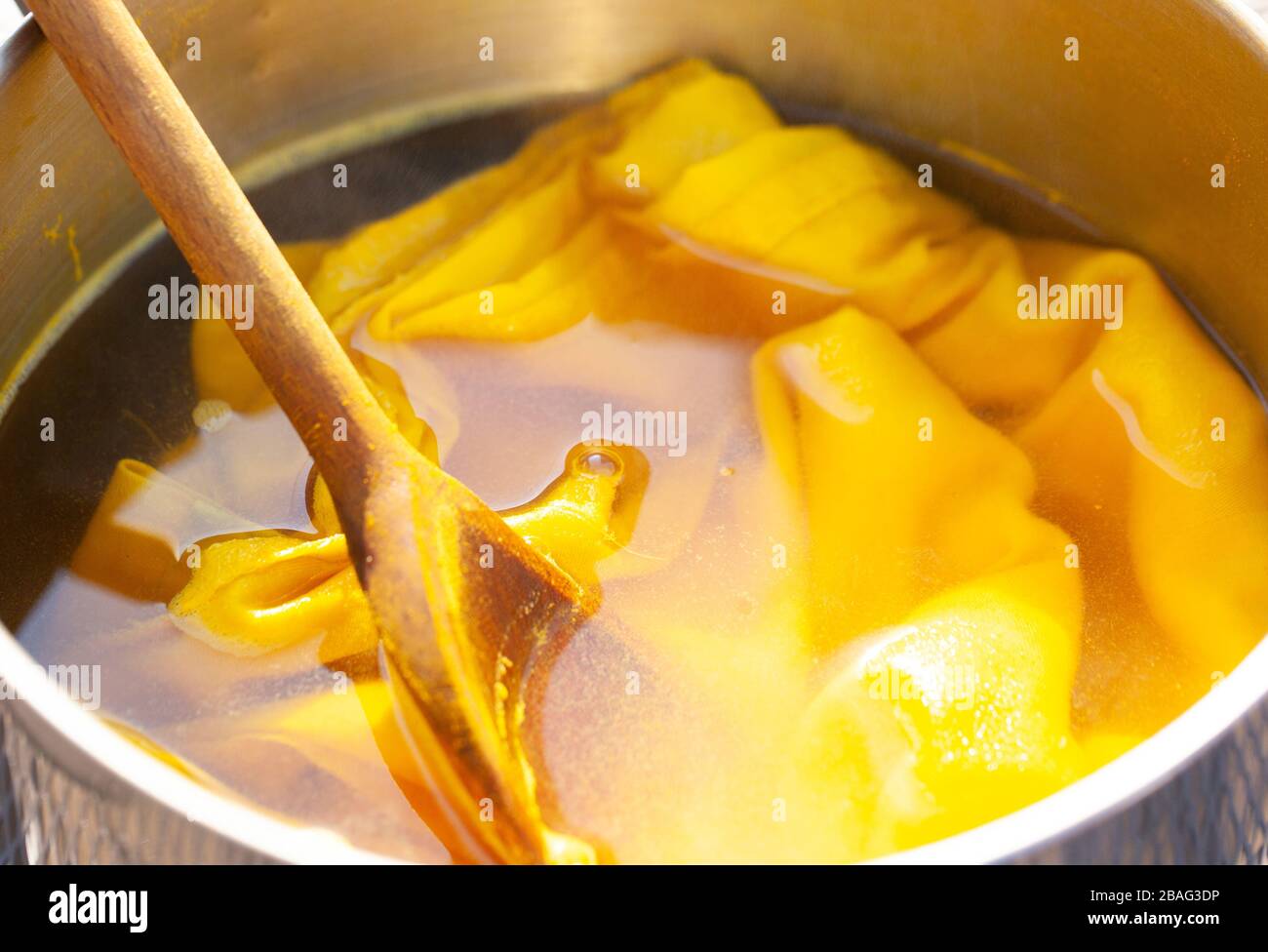 Tendenza al colore giallo: Fotografia ravvicinata di tessuti e materiali utilizzati durante un processo di tintura naturale. CopySpace Foto Stock