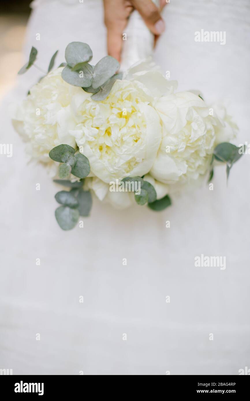 La sposa sta tenendo un fiore nuziale nella sua mano. Foto Stock