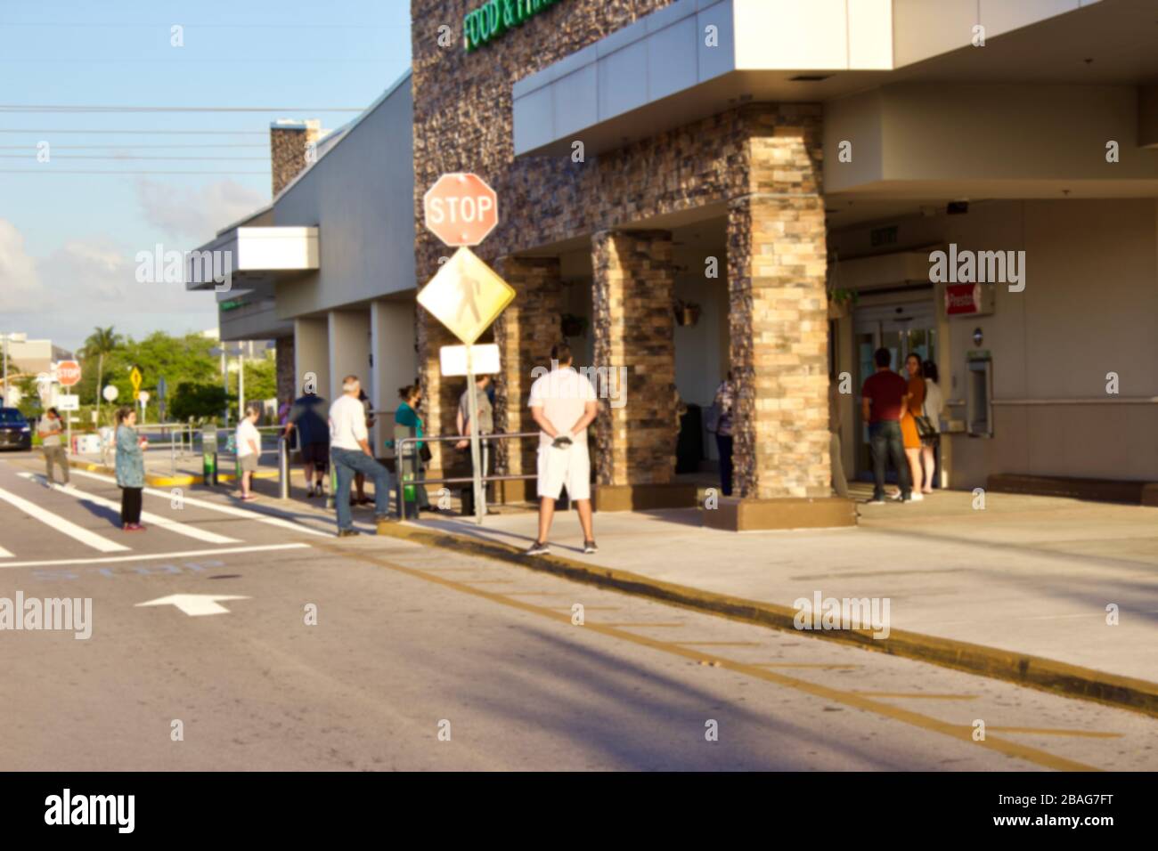 Miami,FL3/22/2020-persone di fronte al negozio pratica allontanamento sociale per la sicurezza.intenzionalmente offuscato. Foto Stock