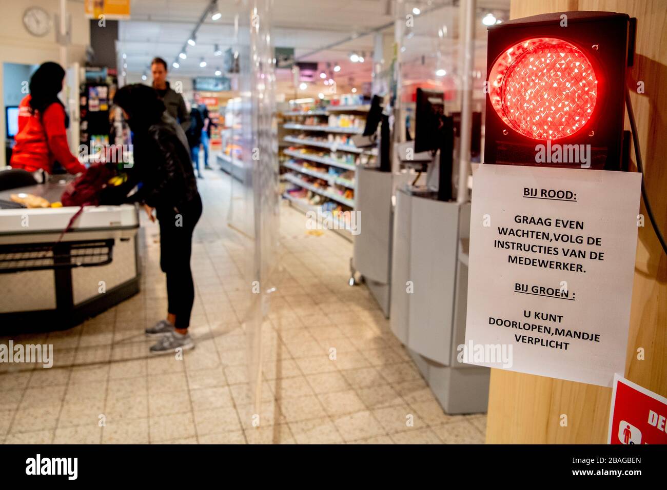 Un supermercato MCW di Utrecht ha installato un semaforo per garantire che non troppi clienti entrino nel negozio. Per prevenire l'infezione da coronavirus COVID-19, i negozi devono consentire solo un numero limitato di clienti alla volta. Foto Stock