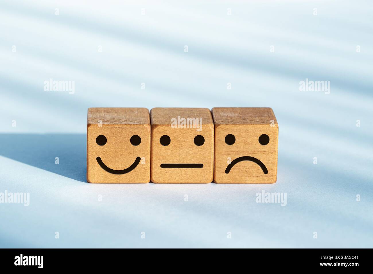Concetto di valutazione del servizio. Valutazione del feedback. Icona smiley su dadi di legno Foto Stock