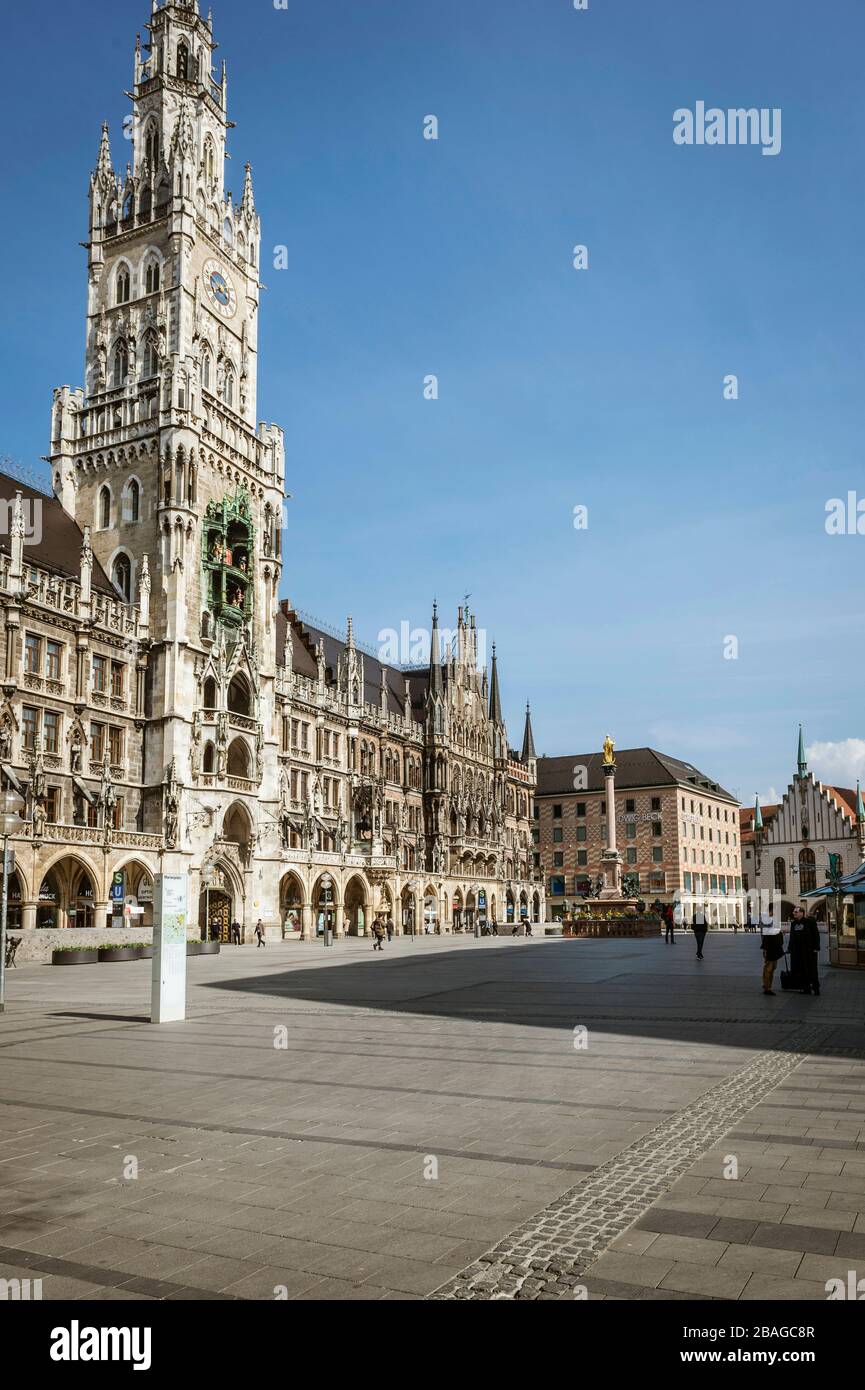 Baviera-Monaco-Germania, 20. März 2020: Poche persone camminano sulla piazza Marienplatz di Monaco, che è di solito affollata, ma rimane vuota a causa del nuovo arredo Foto Stock