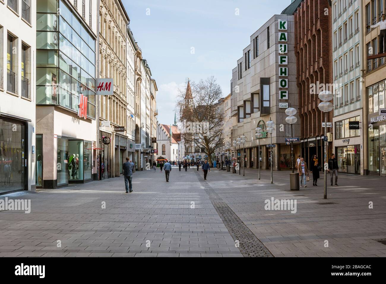 Baviera-Monaco-Germania, 20. März 2020: Poche persone camminano sulla piazza Marienplatz di Monaco, che è di solito affollata, ma rimane vuota a causa del nuovo arredo Foto Stock