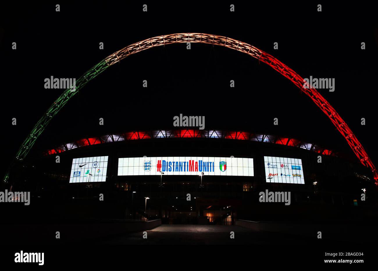 L'arco di Wembley a Londra è illuminato dai colori della bandiera italiana come gesto di solidarietà da parte della squadra di calcio inglese. Foto Stock