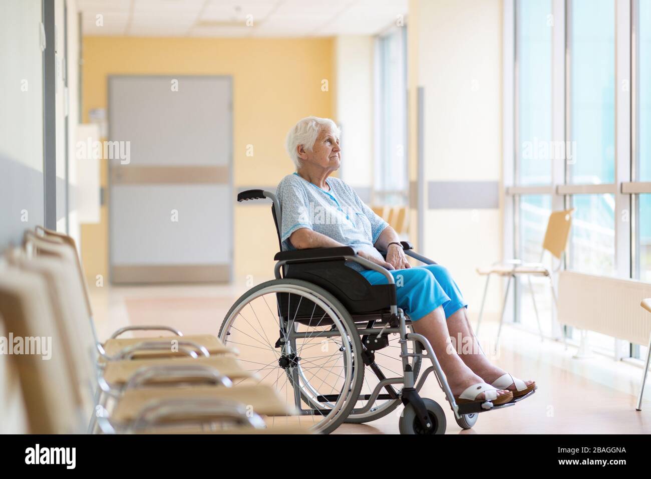 Donna anziana seduta in sedia a rotelle in ospedale Foto Stock