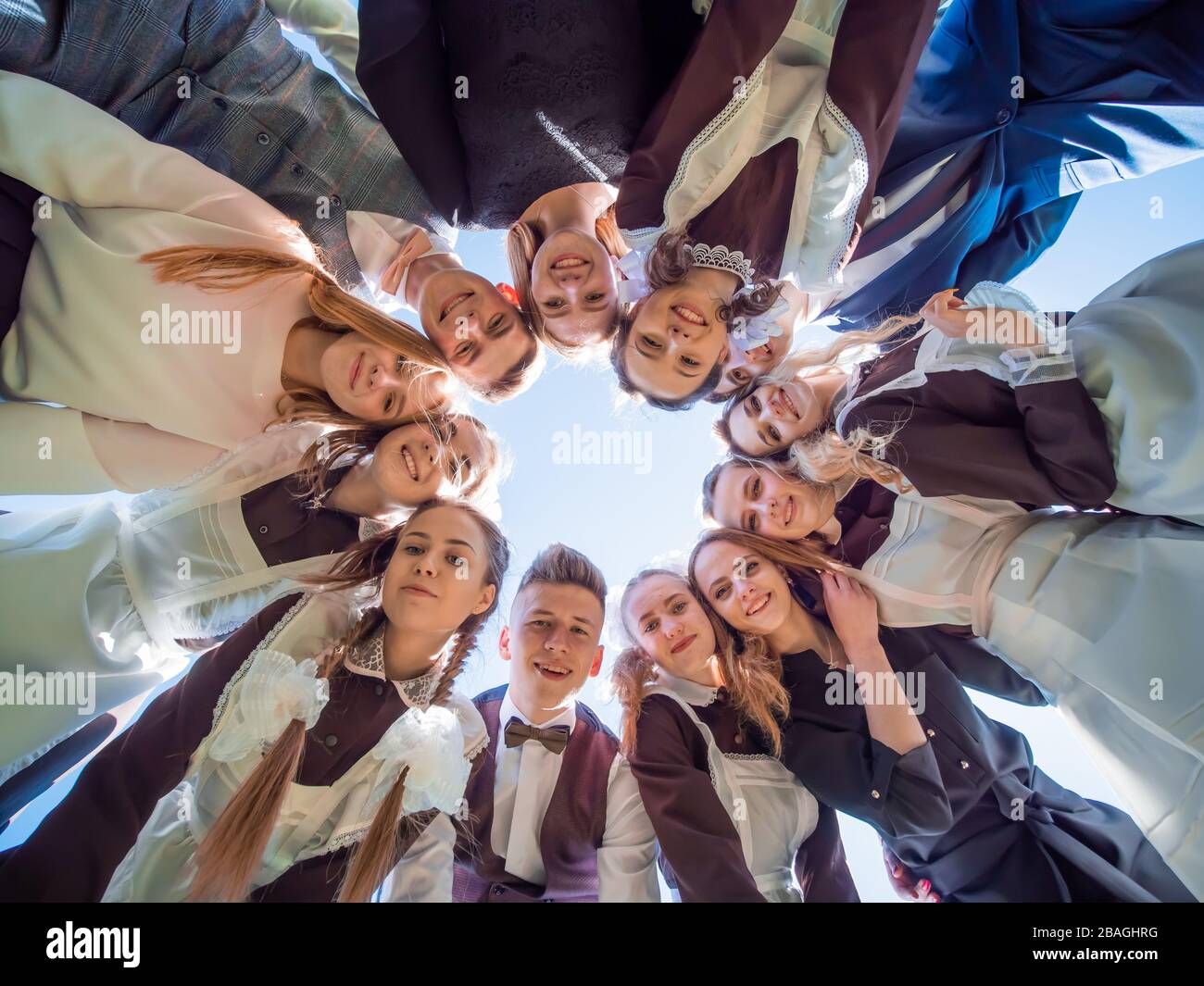 Un gruppo di laureati in una scuola superiore in un cerchio guardare giù. Il concetto di studenti amichevoli. Foto Stock