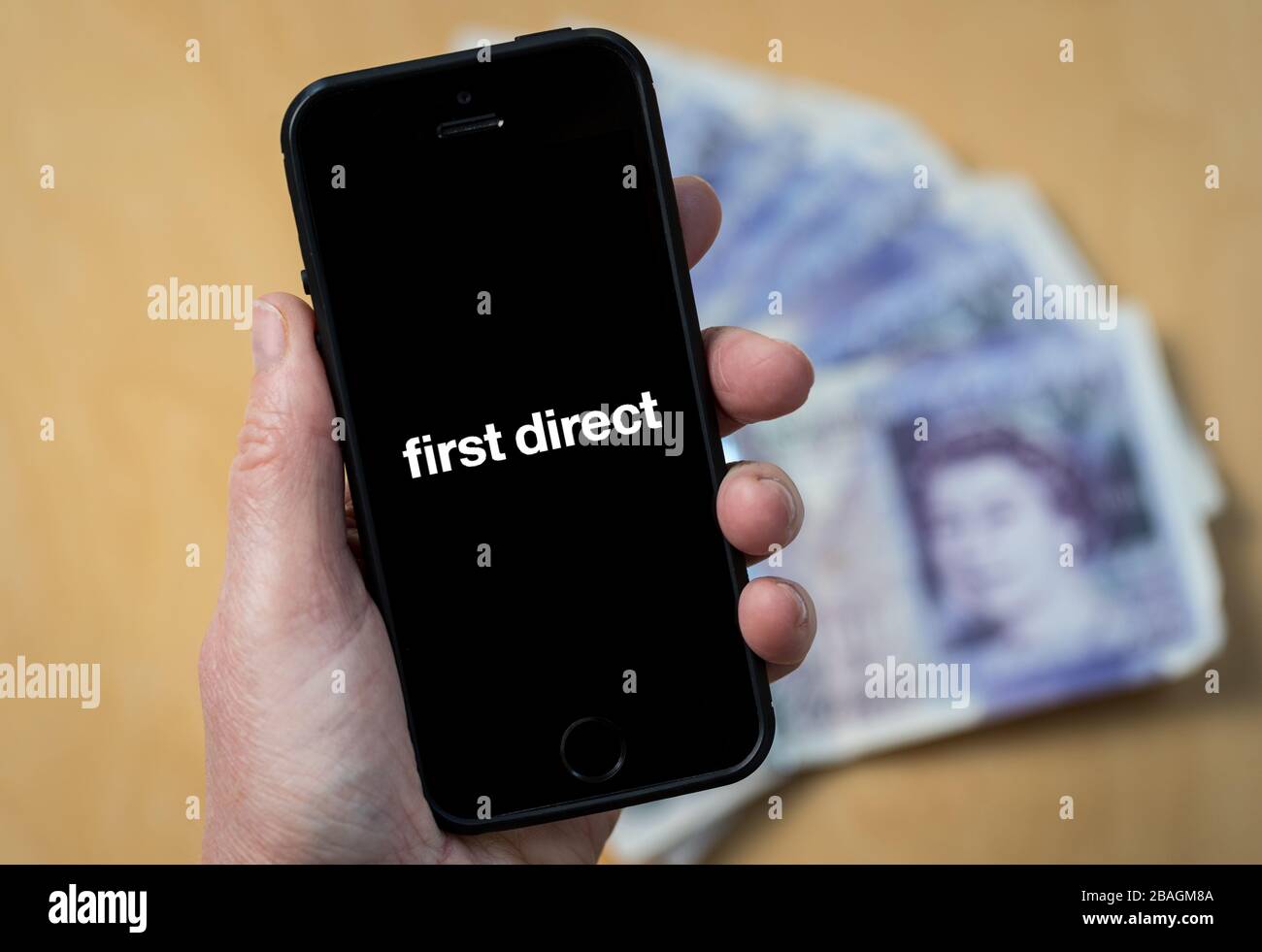 Una donna che guarda il primo logo Direct Bank su un telefono cellulare. (Solo per uso editoriale) Foto Stock