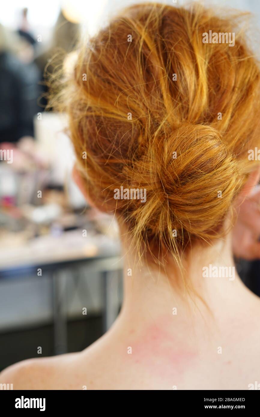 Giovane donna seduta per capelli e trucco con un disordinato pelo di capelli Foto Stock