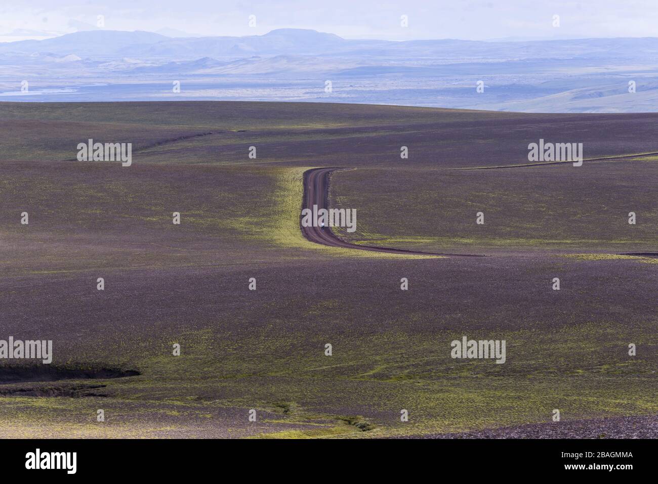 Donna in piedi nel mezzo del nulla su strada sterrata in altopiani Foto Stock